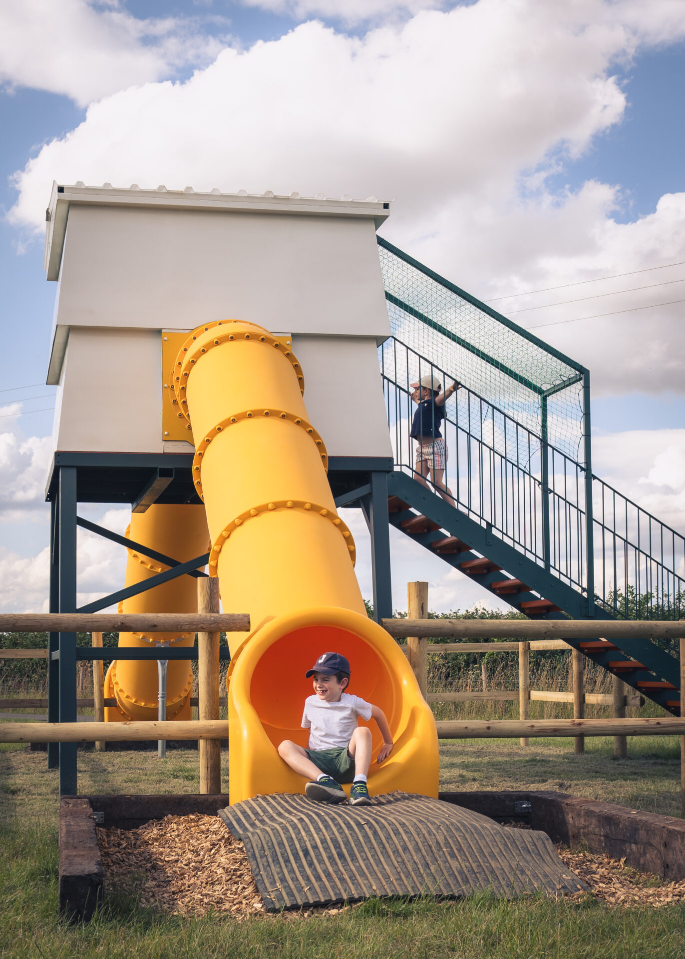 little boy getting up from the end of the slide