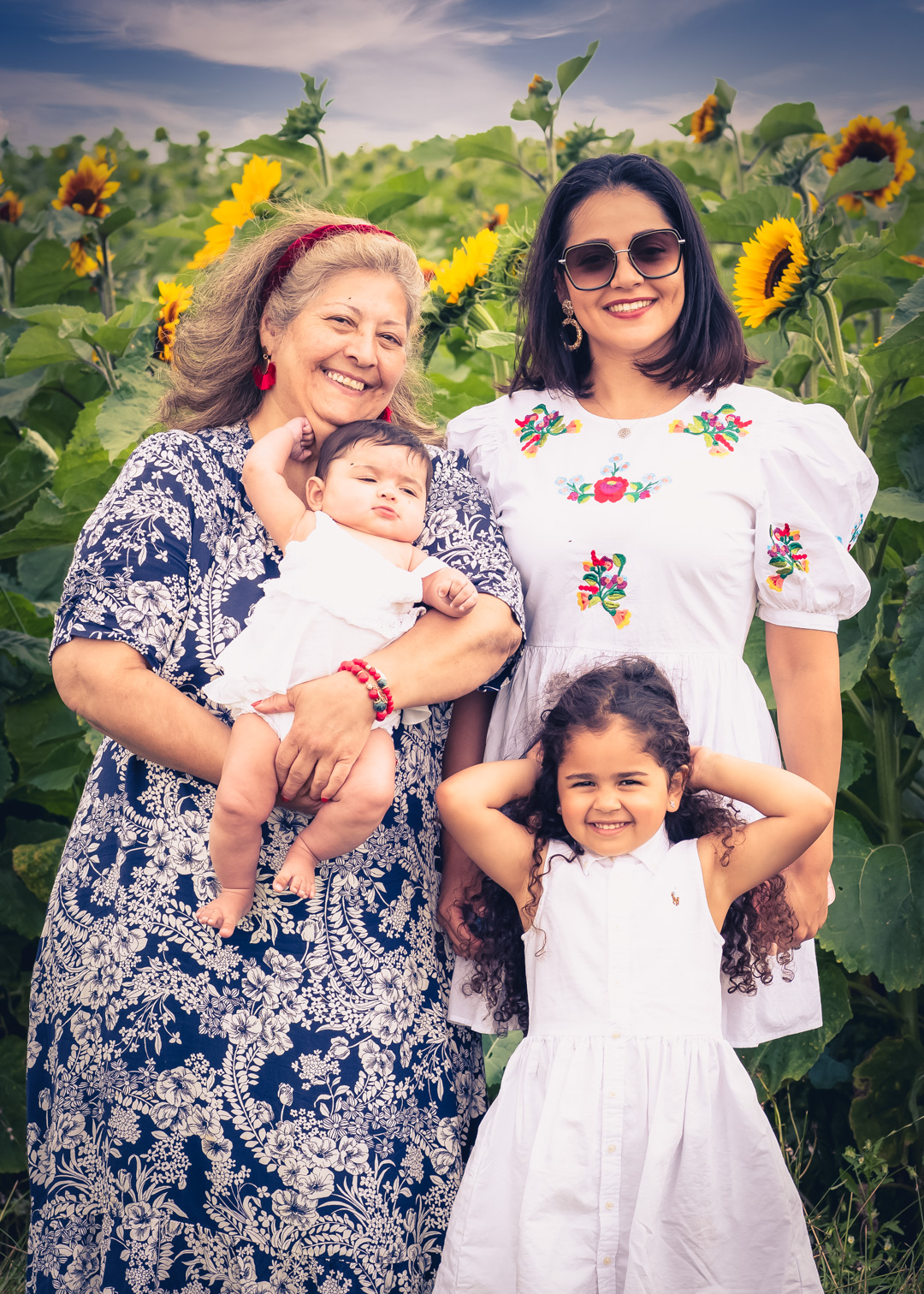 family posing for a photo in front of the sunflower fields